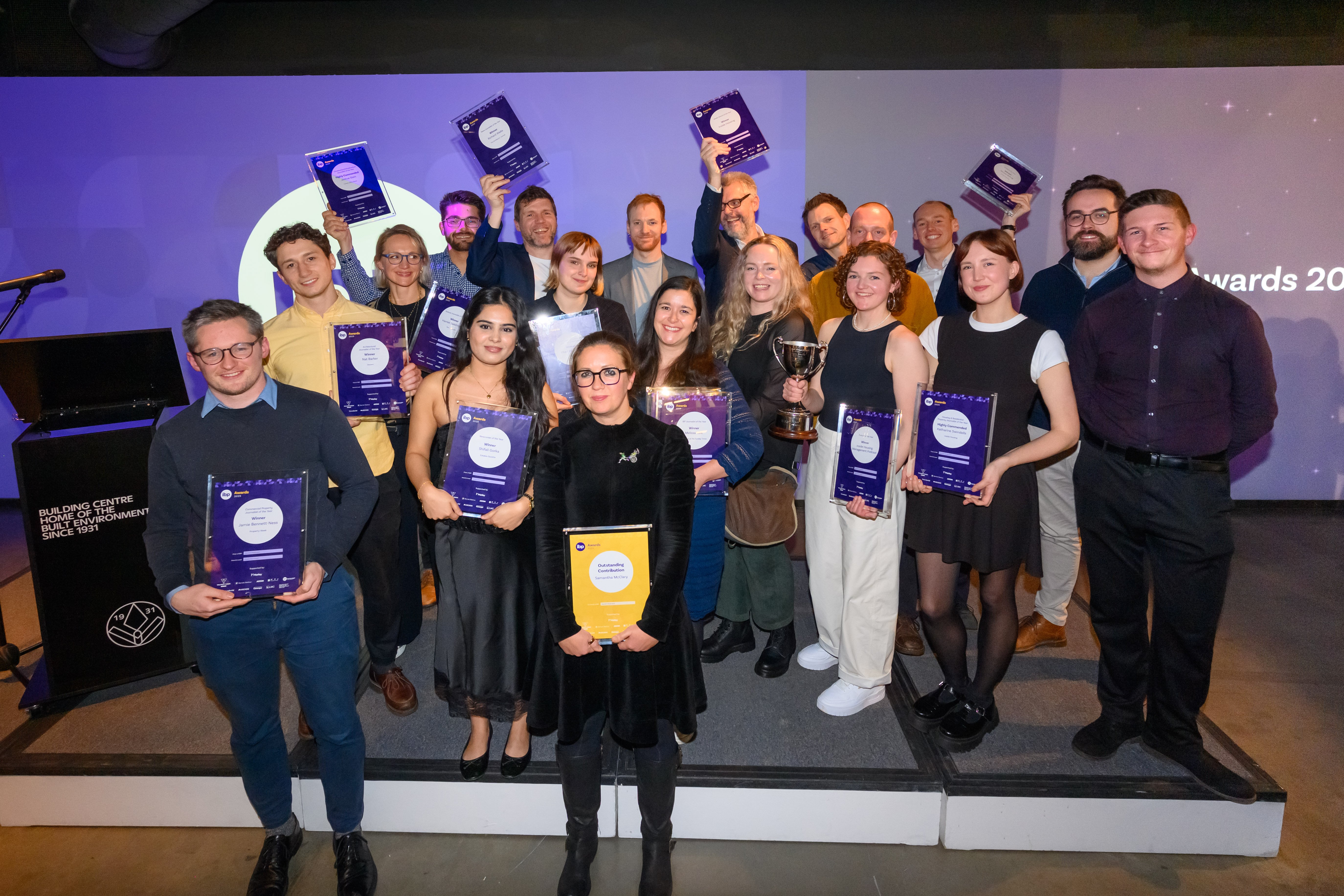 The winners of the IBP Awards 2025 gather on stage, showing off their certificates